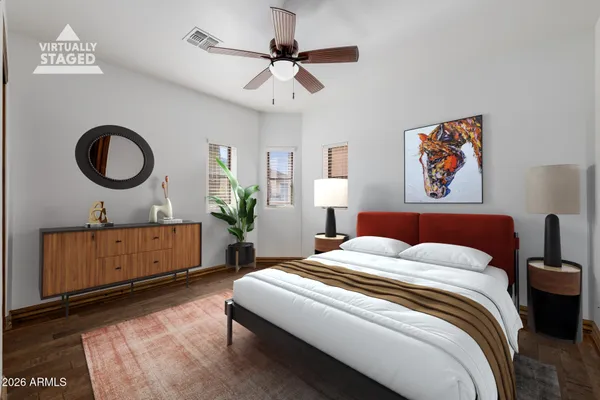 an empty room with wooden floor ceiling fan and windows