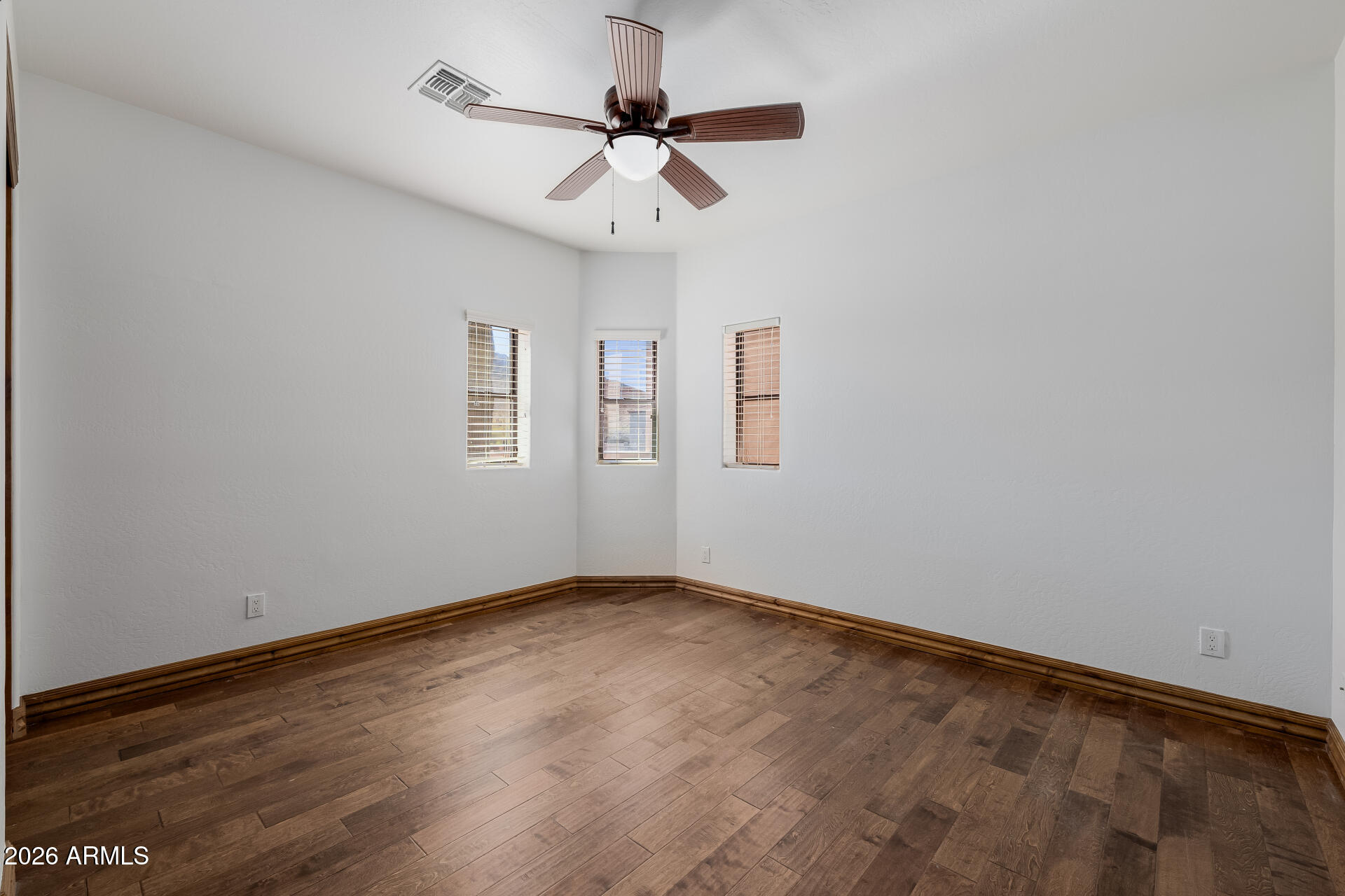 1815 West Maddock Road Phoenix, AZ 85086 - Photo 47 of 71 an empty room with wooden floor ceiling fan and windows
