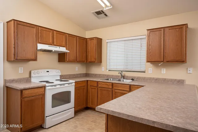 a kitchen with stainless steel appliances granite countertop a refrigerator sink and stove