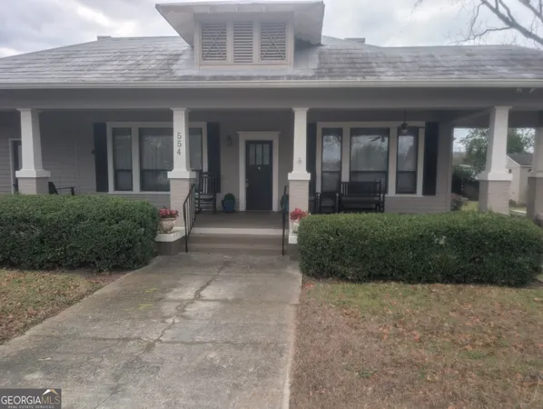 front view of a brick house with potted plants