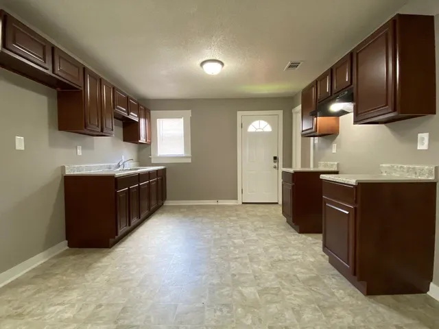 a kitchen with stainless steel appliances granite countertop a sink stove and cabinets
