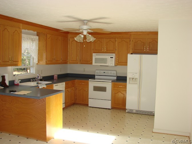 16145 Glebe Road Dewitt, VA 23840 - Photo 7 of 15 a kitchen with a stove a sink and a refrigerator