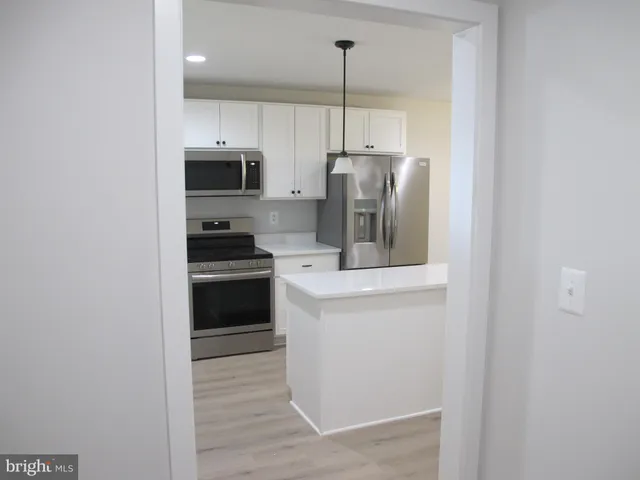 a kitchen with a sink white cabinets and stainless steel appliances