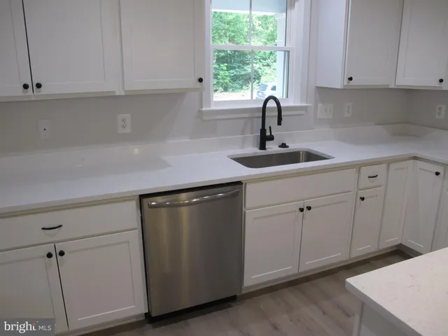 en empty room with windows and chandelier fan