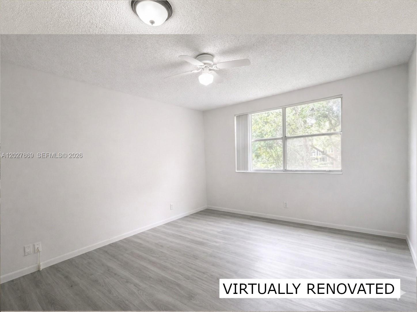 8761 Wiles Road, Unit 206 Coral Springs, FL 33067 - Photo 9 of 26 an empty room with windows and fan