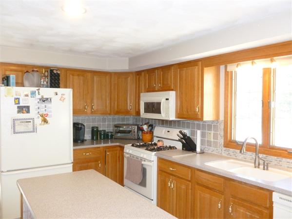 15 Gov Doherty Road Billerica, MA 01821 - Photo 8 of 30 a kitchen with a refrigerator a sink a stove and a window