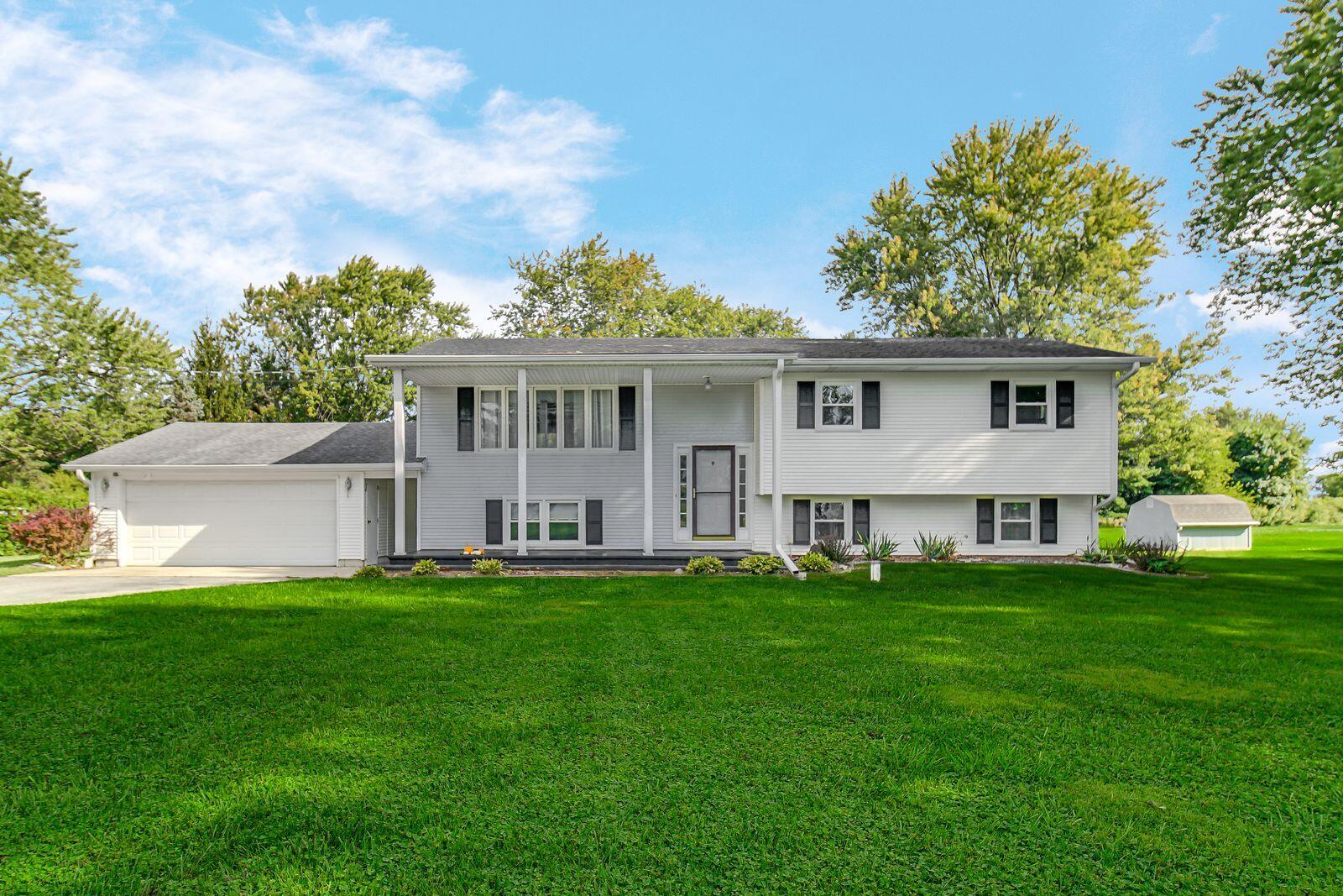 a front view of a house with a yard and trees