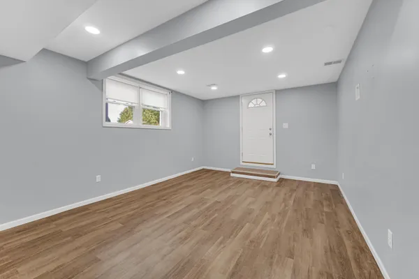 an empty room with wooden floor and window