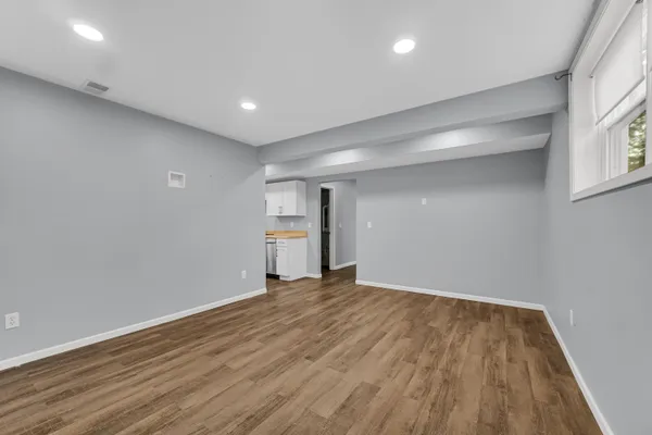 a view of empty room with wooden floor