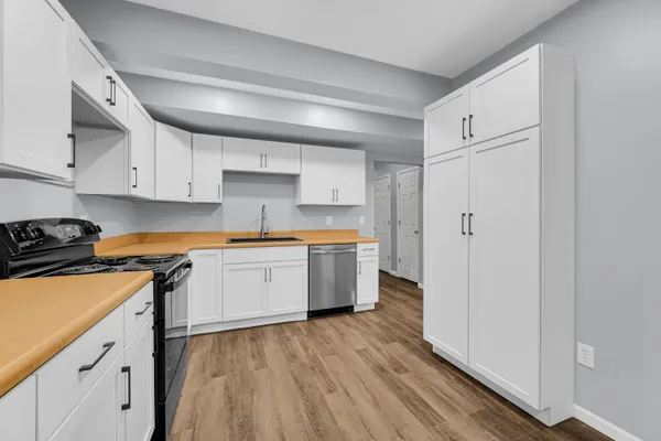 a kitchen with wooden floors and white appliances