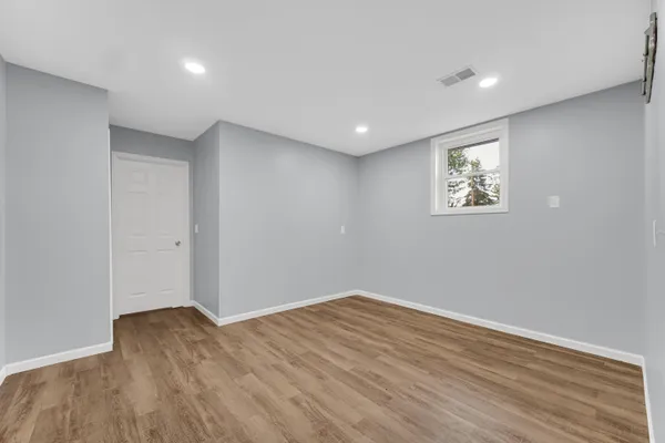 a view of empty room with wooden floor