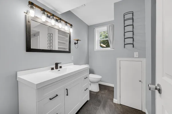 a bathroom with a toilet sink and mirror