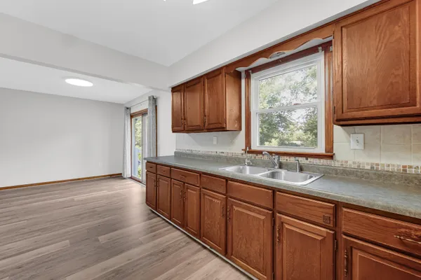 a kitchen with granite countertop wooden cabinets a sink and a window