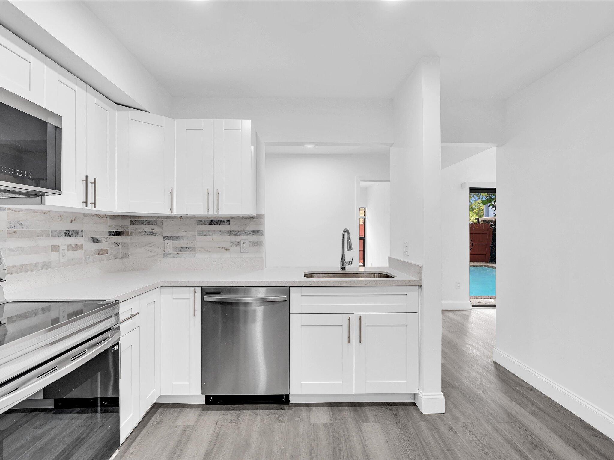 3841 Farragut Street Hollywood, FL 33021 - Photo 12 of 47 a kitchen with stainless steel appliances granite countertop a sink and cabinets