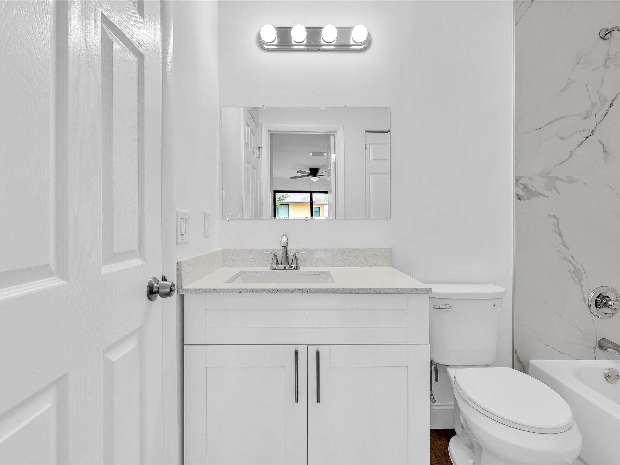3841 Farragut Street Hollywood, FL 33021 - Photo 26 of 47 a bathroom with a granite countertop sink toilet a mirror and vanity