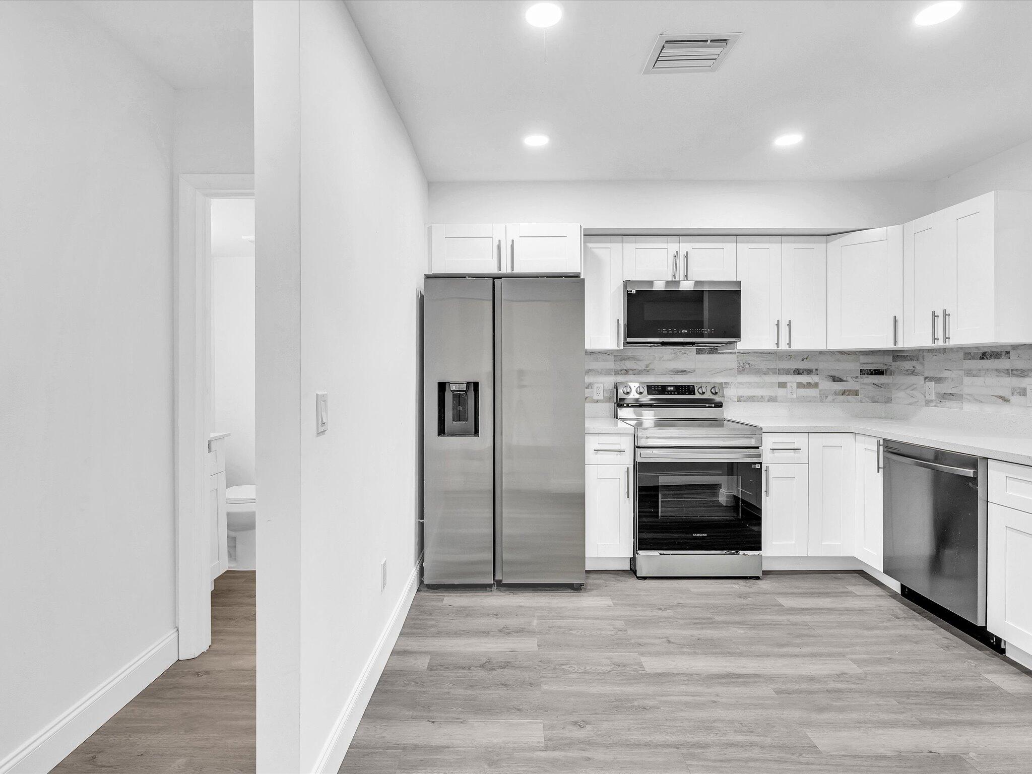 3841 Farragut Street Hollywood, FL 33021 - Photo 38 of 47 a kitchen with stainless steel appliances a stove a microwave and a refrigerator