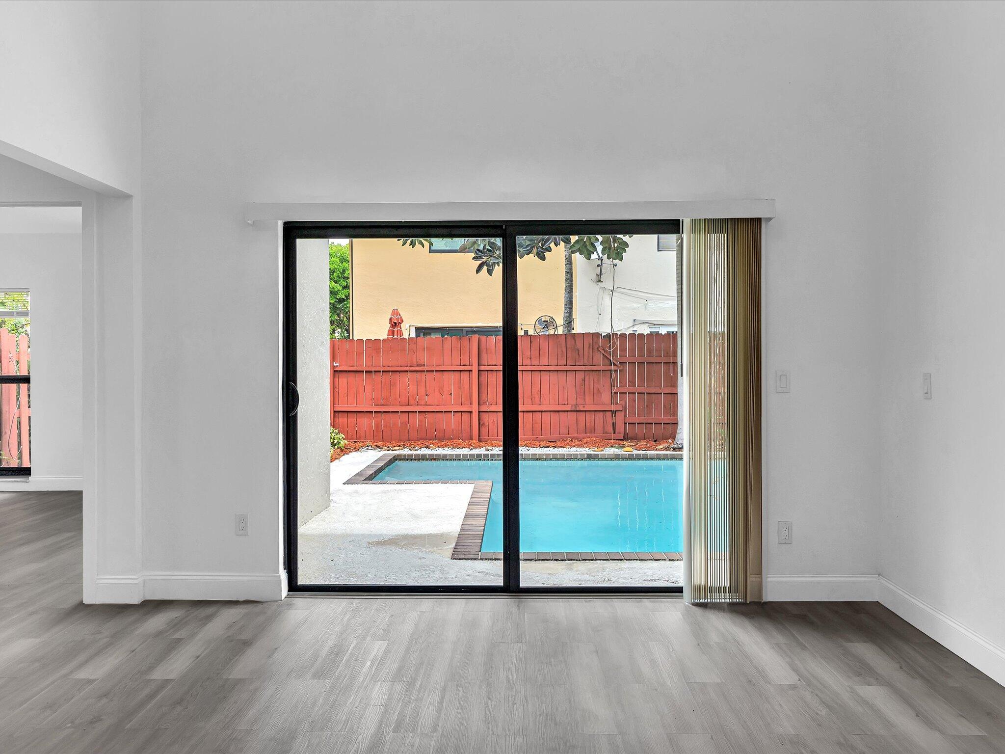 3841 Farragut Street Hollywood, FL 33021 - Photo 42 of 47 an empty room with sliding door and wooden floor
