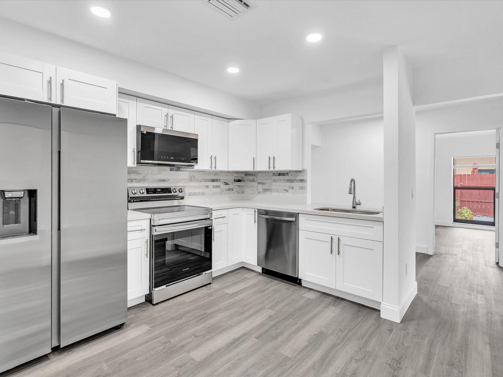 3841 Farragut Street Hollywood, FL 33021 - Photo 10 of 47 a kitchen with cabinets stainless steel appliances and wooden floor