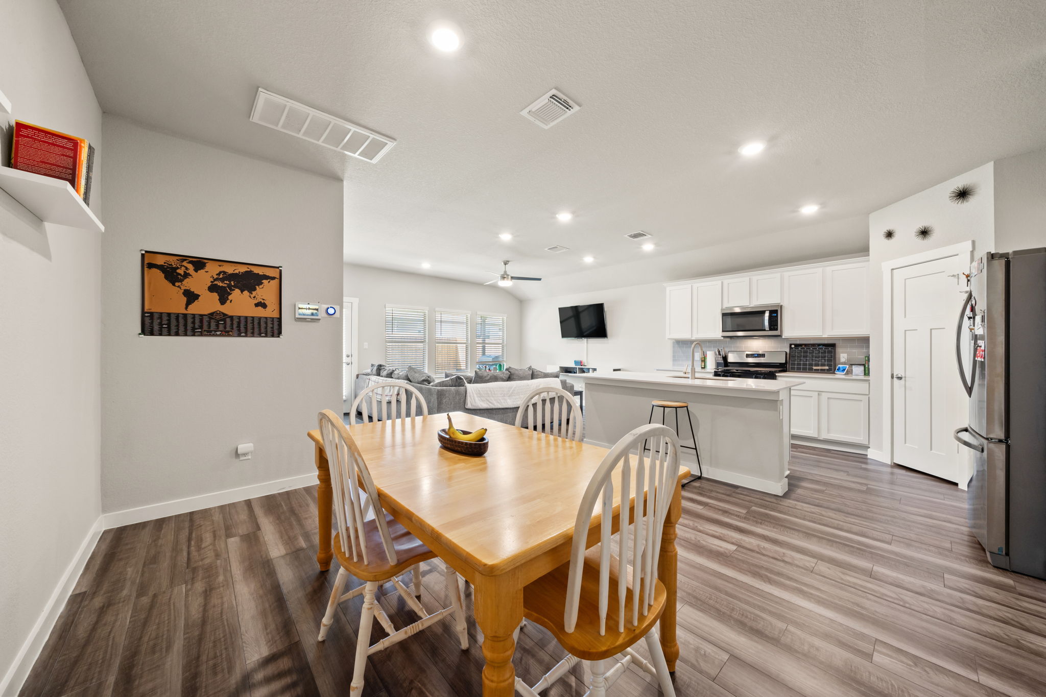 1117 Tipton Street Georgetown, TX 78633 - Photo 10 of 40 Open-concept interior featuring wood-finish flooring, recessed lighting, and a kitchen island with a stainless steel sink