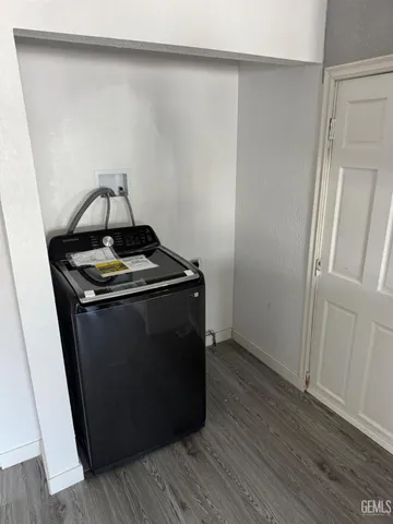 a utility room with wooden floor washer and dryer