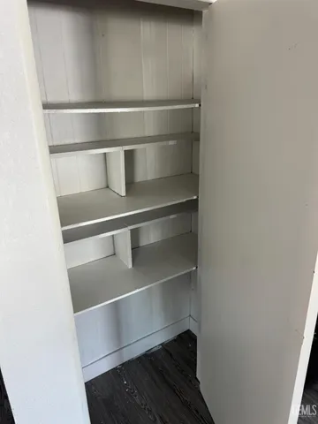 a view of walk in closet with empty racks