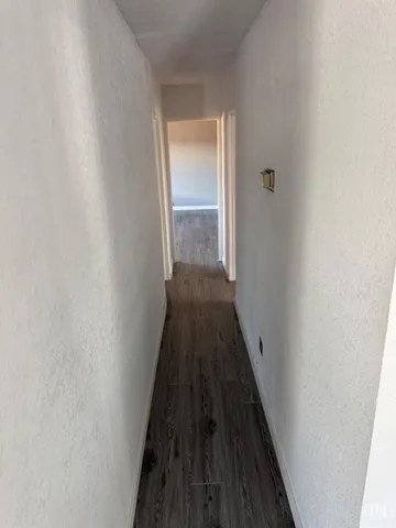 a view of a hallway with wooden floor