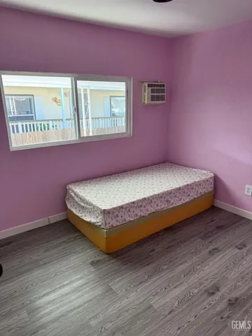 a spacious bedroom with a bed and wooden floor