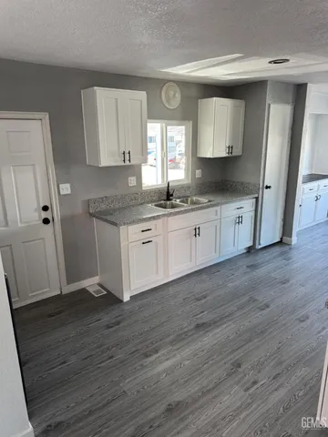 a kitchen with granite countertop a sink and cabinets