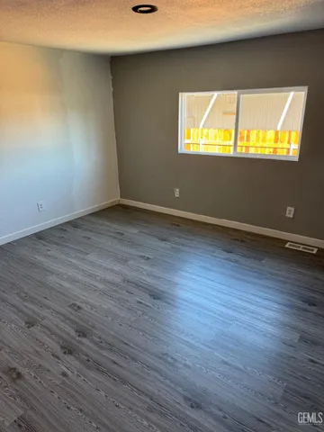 an empty room with wooden floor and a window