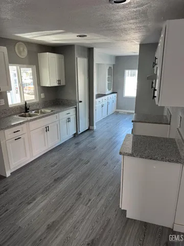 a large kitchen with granite countertop a large counter top space and windows