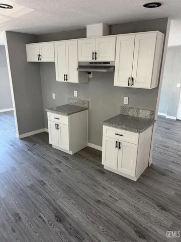 a kitchen with stainless steel appliances granite countertop a sink a stove and a wooden floors