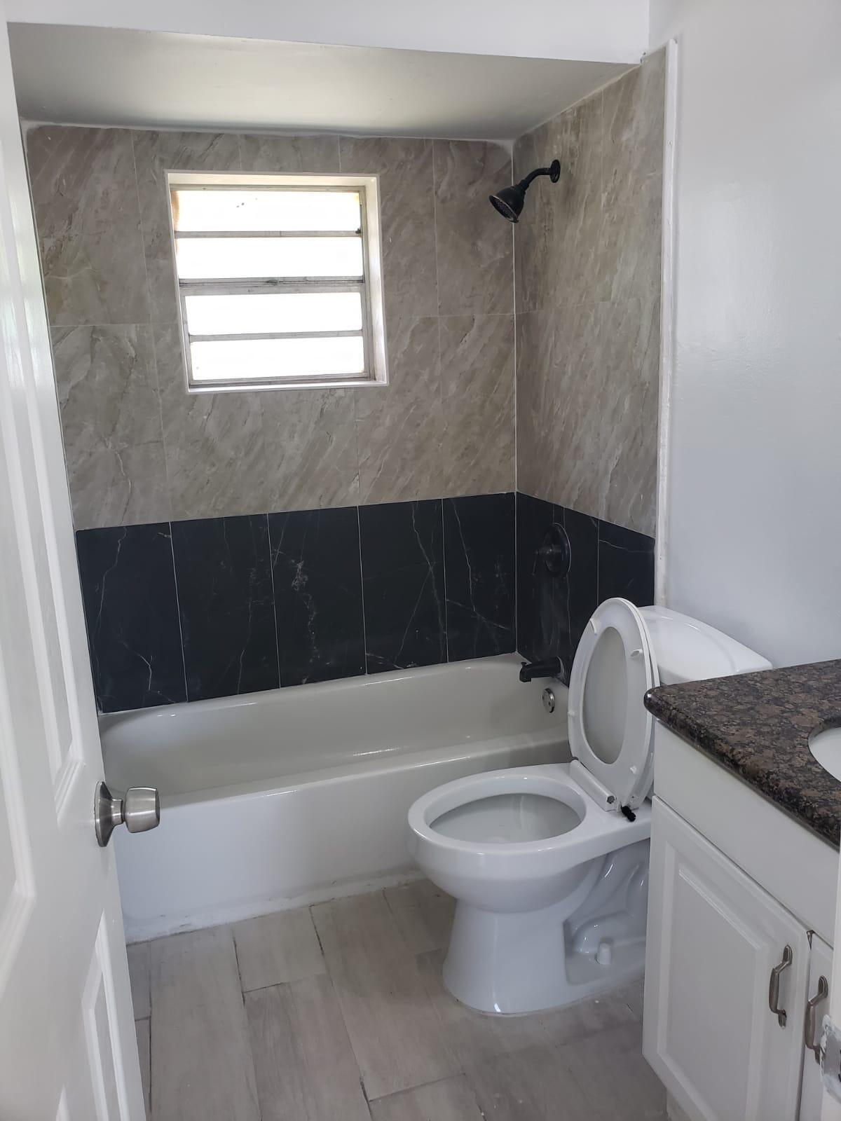 a bathroom with a granite countertop toilet a sink and bathtub