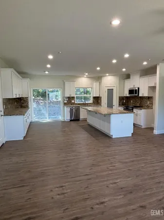 a kitchen with stainless steel appliances granite countertop a refrigerator and a stove top oven