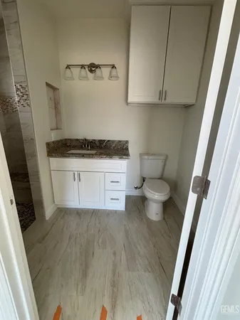 a bathroom with a granite countertop toilet and a sink
