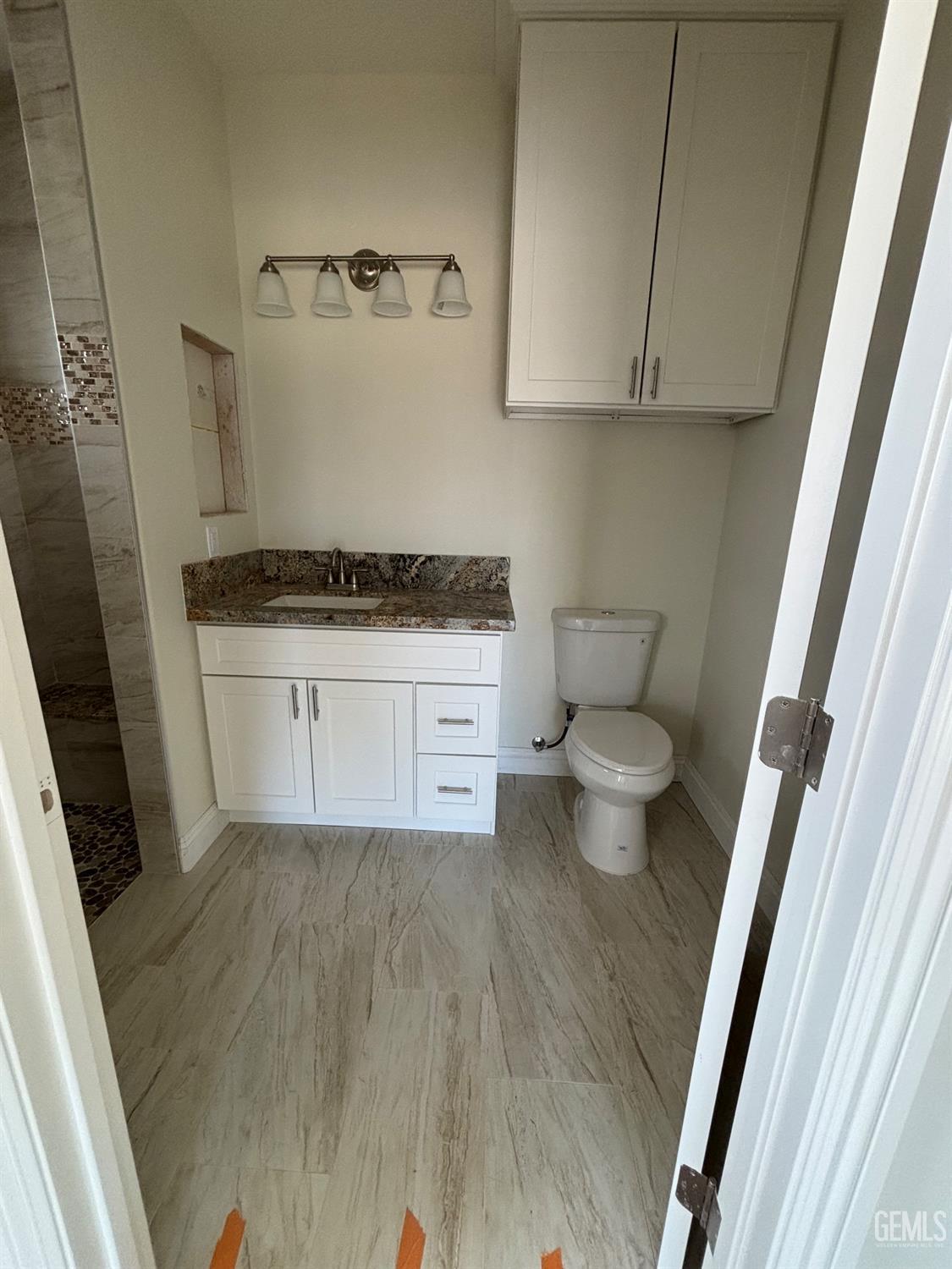 Undisclosed Address Tehachapi, CA 93561 - Photo 8 of 14 a bathroom with a granite countertop toilet and a sink