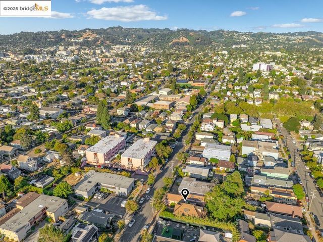 an aerial view of residential houses with outdoor space and trees