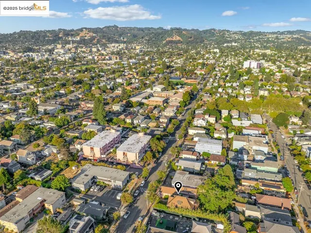 an aerial view of residential houses with outdoor space and trees