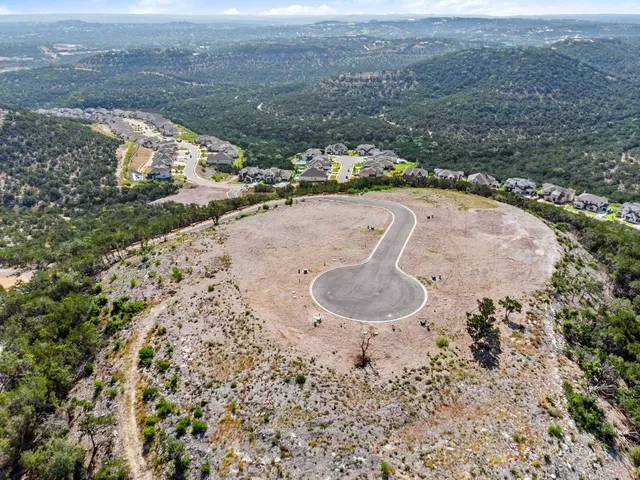 an aerial view of a house with a yard and lake view