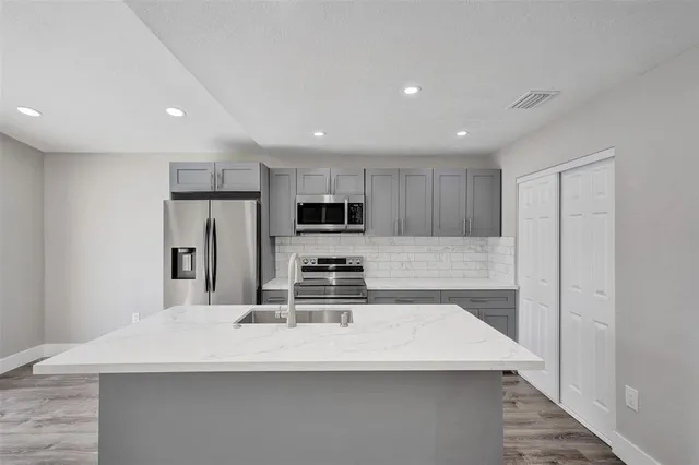a kitchen with stainless steel appliances a refrigerator sink and microwave