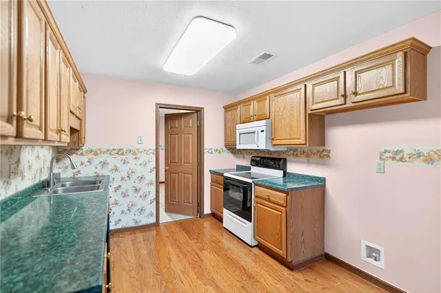 a kitchen with stainless steel appliances granite countertop a sink and a stove
