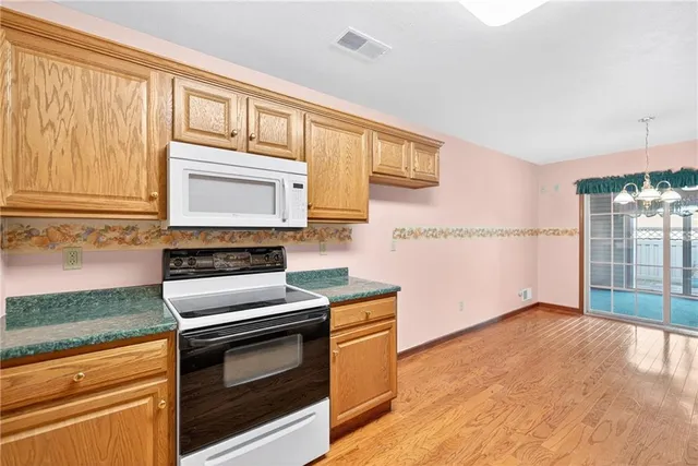 a view of kitchen with granite countertop cabinets and refrigerator