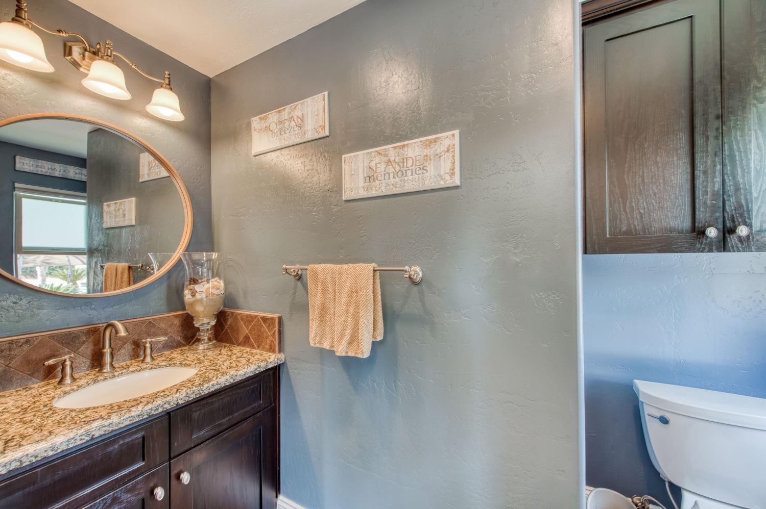 5588 North McCall Avenue Clovis, CA 93619 - Photo 27 of 77 a bathroom with a granite countertop sink and a mirror