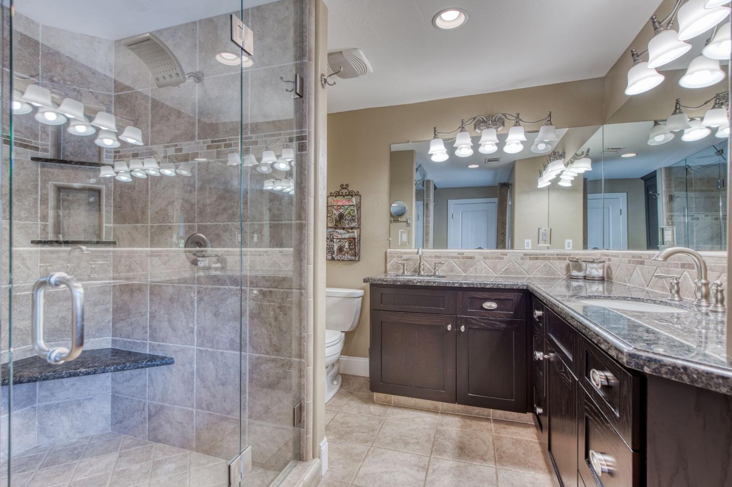 5588 North McCall Avenue Clovis, CA 93619 - Photo 32 of 77 a bathroom with a granite countertop sink a large mirror and a shower