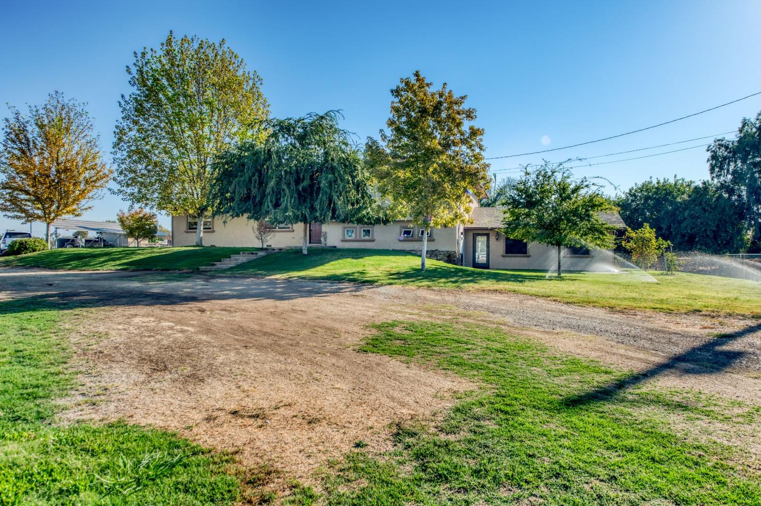 5588 North McCall Avenue Clovis, CA 93619 - Photo 74 of 77 a view of a house with a big yard and palm trees