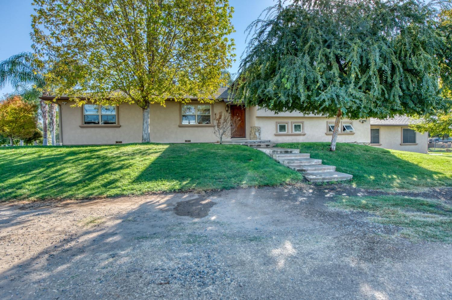 5588 North McCall Avenue Clovis, CA 93619 - Photo 76 of 77 a front view of a house with a yard and garage
