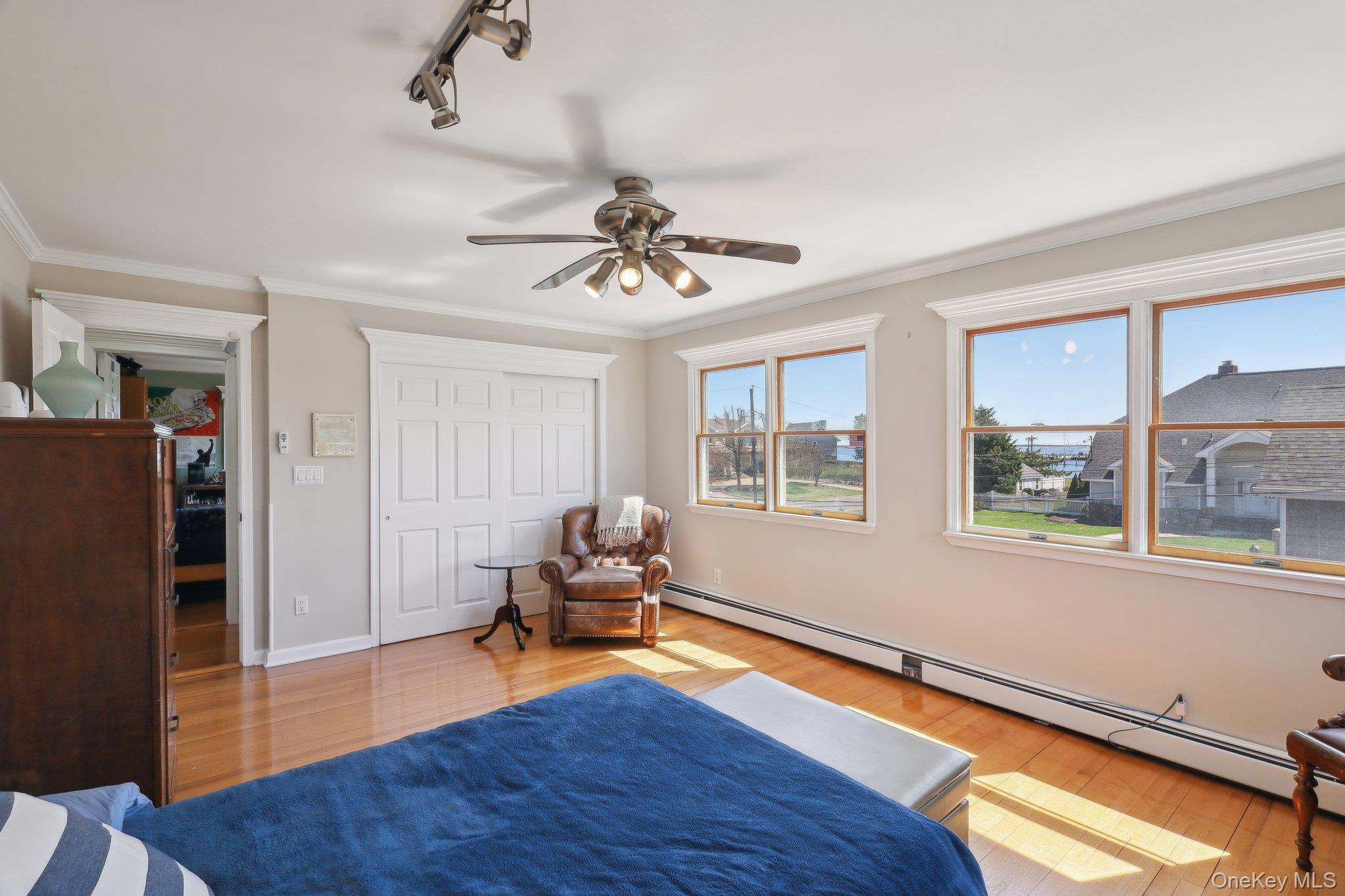 230 West Islip Road West Islip, NY 11795 - Photo 22 of 50 Bedroom with crown molding, a closet, baseboard heating, wood finished floors, and baseboards