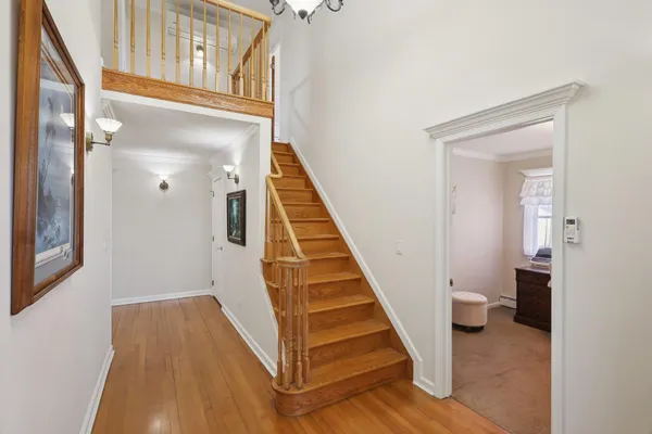 a view of a hallway with wooden floor and staircase