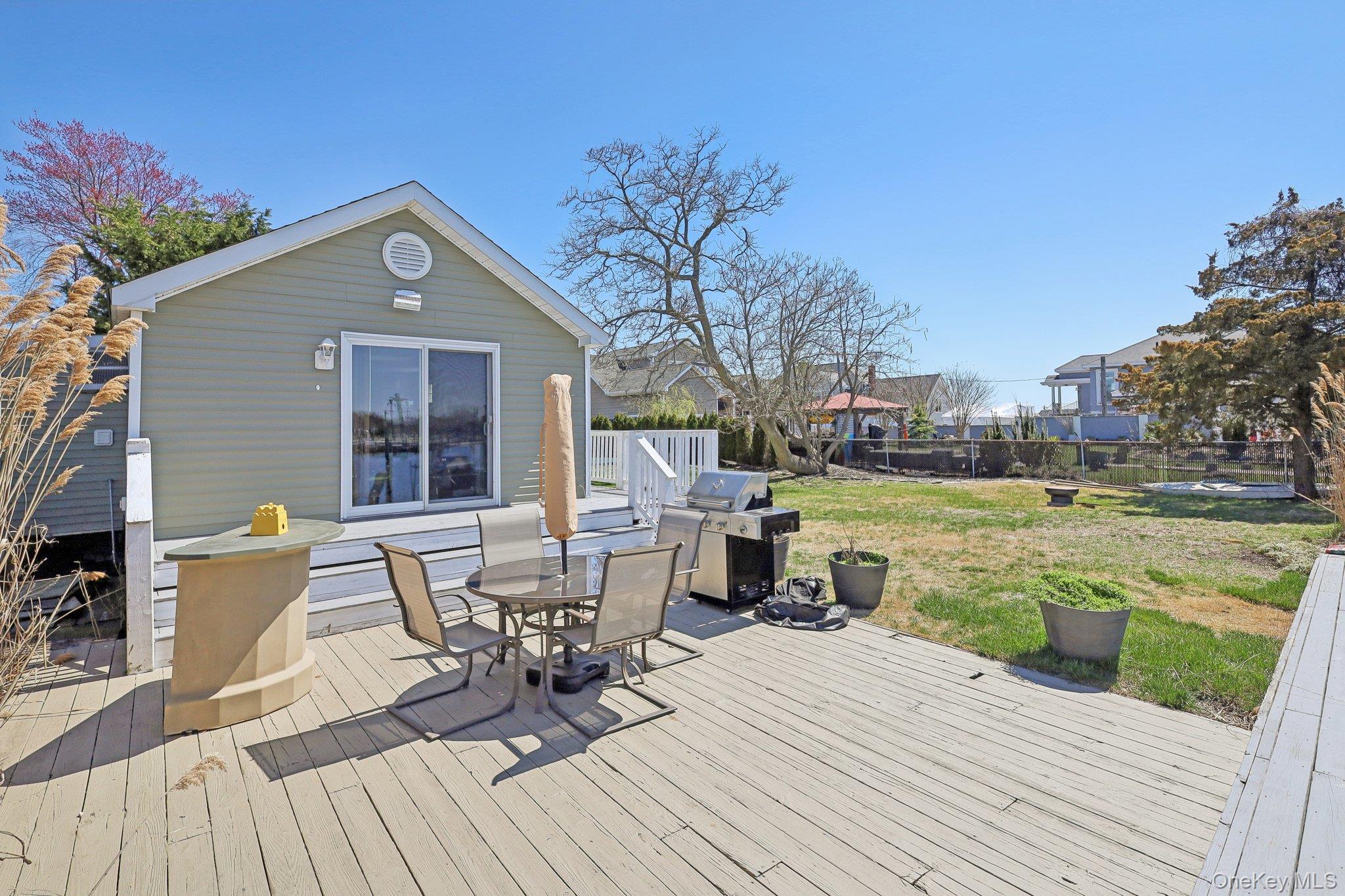 230 West Islip Road West Islip, NY 11795 - Photo 42 of 50 Deck featuring a grill, a yard, fence, and outdoor dining area