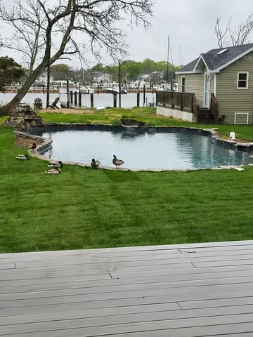 a view of house with yard tennis court