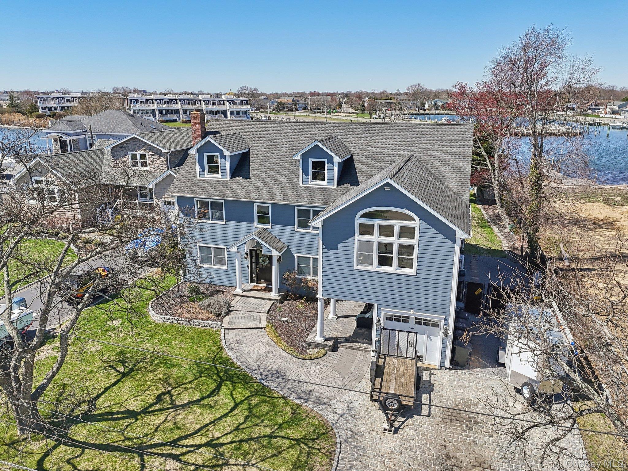 230 West Islip Road West Islip, NY 11795 - Photo 6 of 50 View of front facade featuring a water view, a chimney, a front yard, and roof with shingles